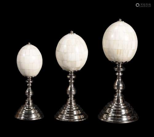 A graduated set of three bone 'eggs' on nickel plated stands by Anthony Redmile
