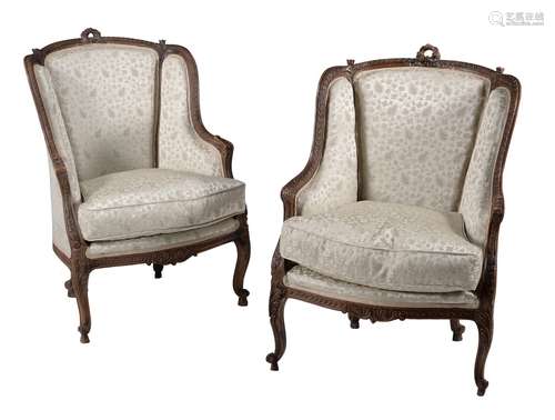 A pair of French carved walnut and upholstered armchairs