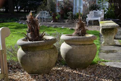 A pair of stone composition garden urns