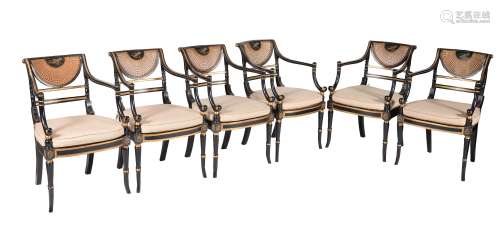 A set of twelve ebonised and parcel gilt armchairs