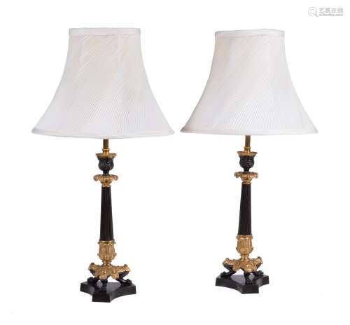 A pair of French gilt and lacquered metal candlesticks in Louis Philippe taste refitted as lamps