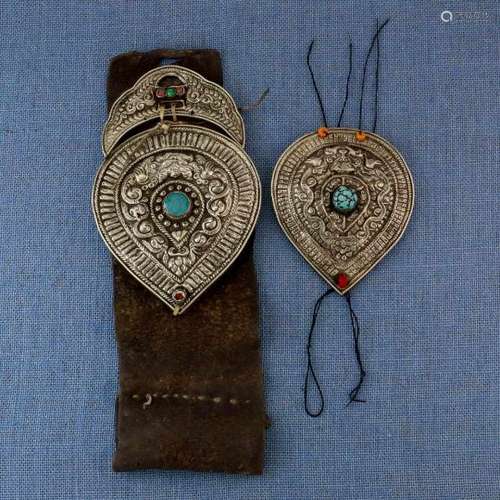 Tibet, two metal amuletswith coral, turquoise and glass stones, the hammered relief decoration