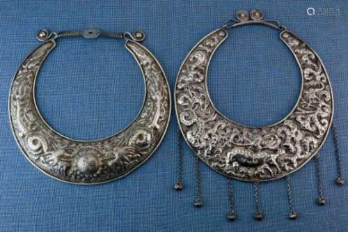 China, Miao, two hollow neck ringswith hammered decorations, one neck ring with the animals of the
