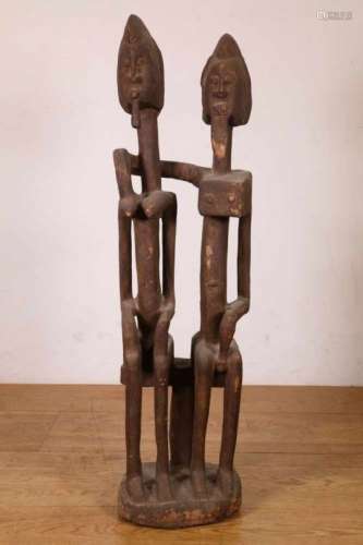 Mali, Dogon, houten beeldengroepvan de twee oervoorouders. Gezeten op een kruk en de man omarmd de