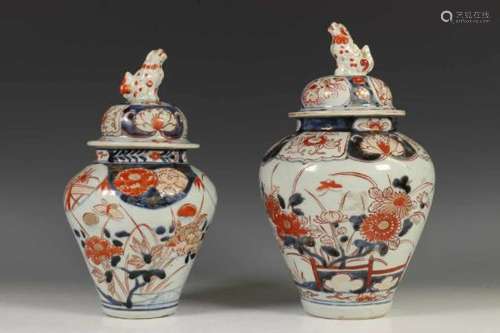 Japan, twee Imari dekselvazen, Edo periode,elk gedecoreerd met pioenrozen en chrysanten, de