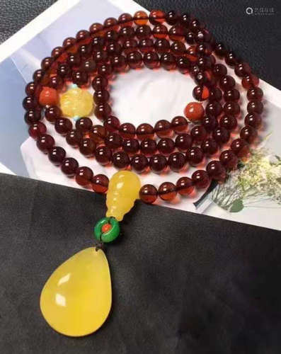 AN AMBER CARVED NECKLACE WITH 108 BEADS