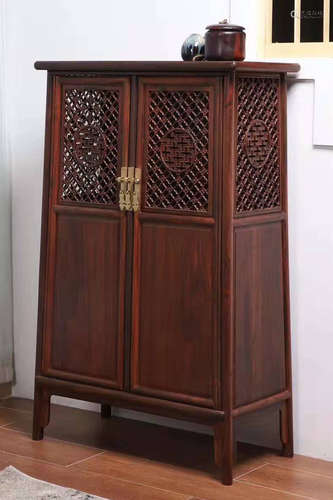 A RED WOOD CABINET CARVED WITH PATTERN