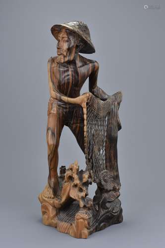 A Southeast Asian Hardwood Figure of a Fisherman