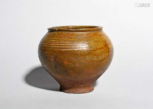 A medieval pottery storage jar, c.14th-16th century, the rounded baluster body lightly incised to