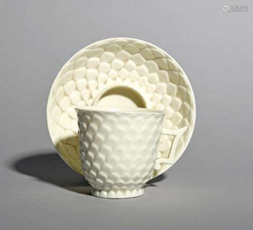 A Saint Cloud white-glazed coffee cup and trembleuse saucer, c.1730-40, moulded in the artichoke