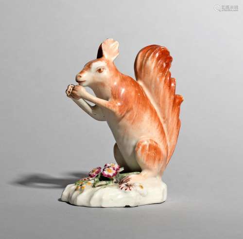 A Derby model of a red squirrel, c.1765, seated on its haunches and eating a nut held in its