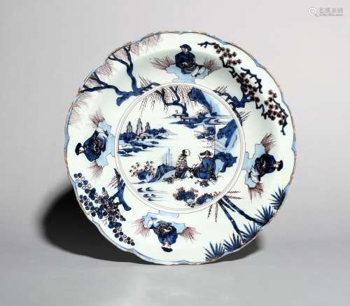 A large Dutch or English Delft charger, c.1670-80, painted in blue and manganese with seated Chinese
