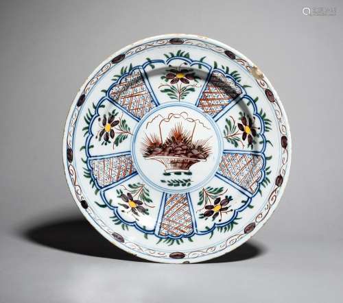 A large Delft charger, c.1730, painted in polychrome enamels with a central basket enclosed by