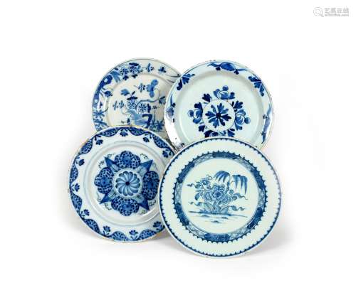 Four delftware plates, c.1740-60, two painted in blue with differing designs of flowering Oriental
