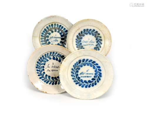 Four Delft 'Merry Man' plates, late 17th century, each well inscribed in Dutch with a line from