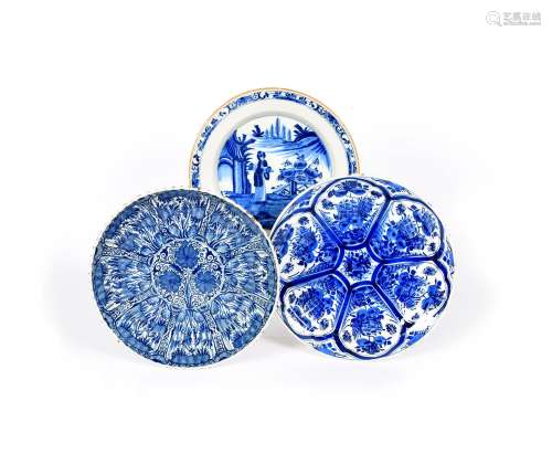 Three Delft chargers, 18th century, one fluted and painted with a dense foliate design, another
