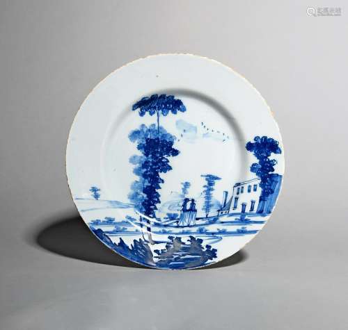 A Bristol delftware plate, c.1760, of Bowen type, painted in blue with two ladies promenading in a