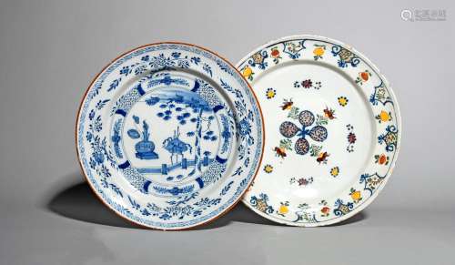 Two Delft chargers, mid 18th century, the smaller painted in blue with a vase and censer beside a