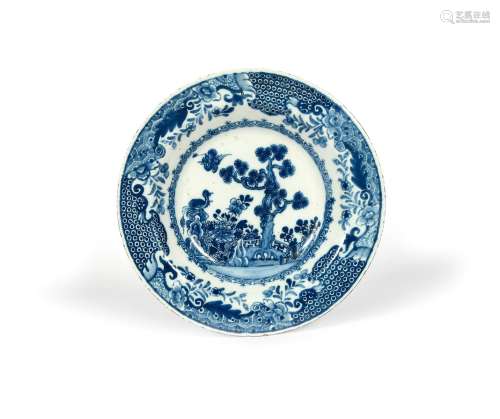A Dublin delftware soup plate, c.1760, painted with a bird in flight above a pine tree encircled