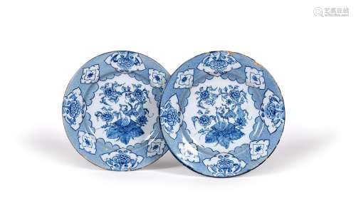 A pair of delftware plates, c.1760, each painted in blue with a kylin seated on a square cushion