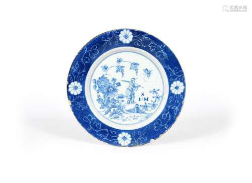 A Lambeth delftware plate, dated 1748, painted in blue with a Chinese figure holding a long