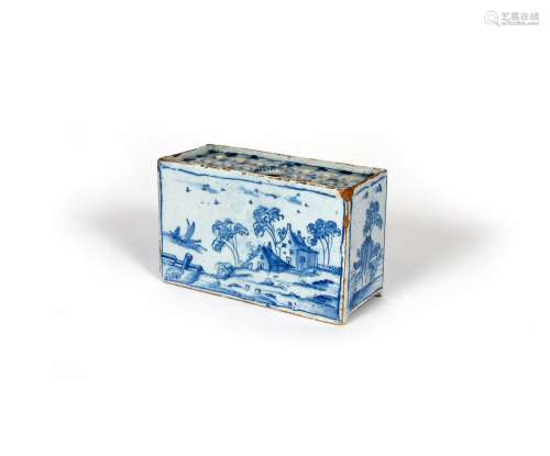 A delftware flower brick, c.1760, of rectangular form, the long sides painted with landscape