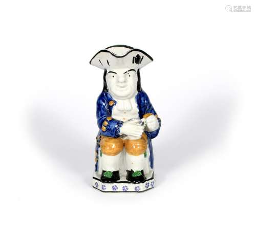 A Yorkshire pearlware Toby jug, 19th century, with an empty cylindrical mug resting on his left