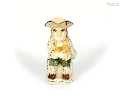 A Pratt ware Toby jug, c.1800, seated and wearing a sprig patterned coat over green breeches and
