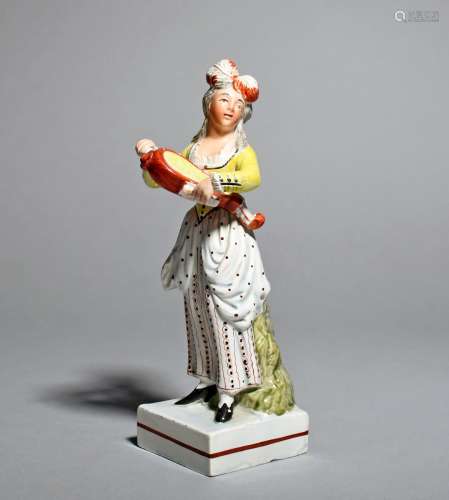 A Staffordshire pearlware figure of a female musician, c.1810-20, standing and playing the hurdy-