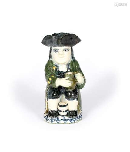 A pearlware Toby jug, c.1790, of Ordinary Wood type, seated with an upright barrel between his