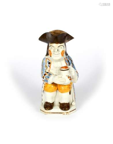 A Pratt ware Toby jug, c.1800, seated and resting a foaming jug of ale on his left knee, his clay