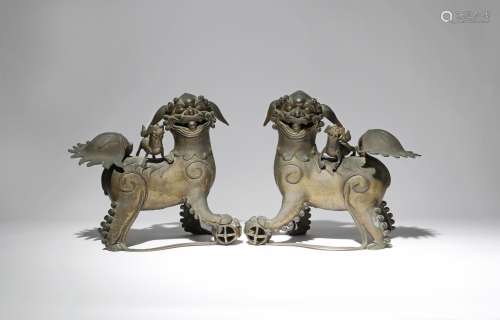A PAIR OF LARGE CHINESE BRONZE MODELS OF LION DOGS QING DYNASTY Each beast depicted with one paw