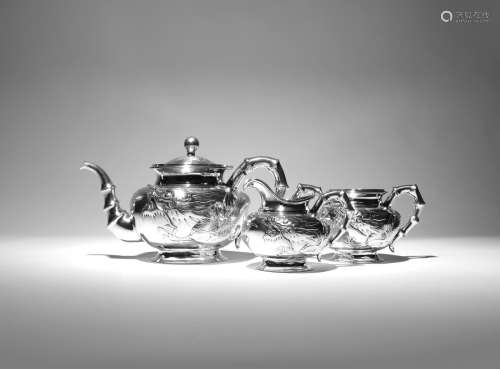 λ A CHINESE SILVER THREE-PIECE TEA SET 19TH CENTURY Comprising: a teapot with a hinged cover, a