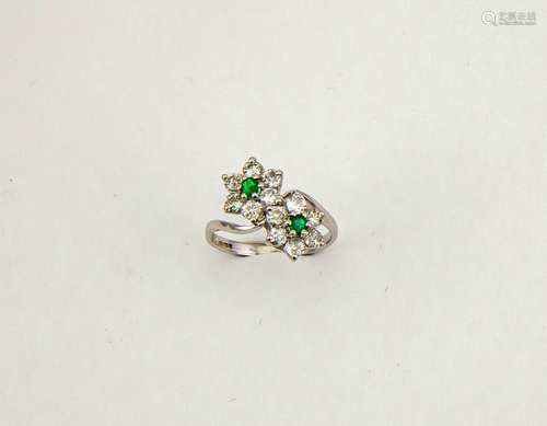 An 18ct white gold, diamond and emerald ring, in the form of a double flower, the brilliant cut