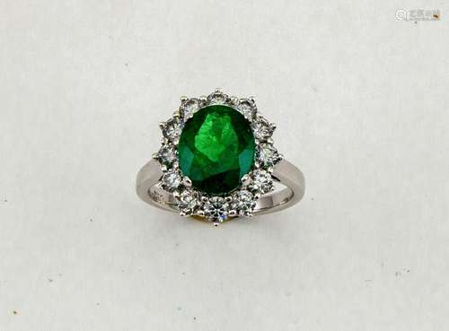 An 18ct white gold, emerald and diamond ring, the central oval cut emerald approximately 2.56ct, and