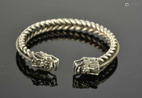 A Tibetan Miao silver dragon bangle, coiled spine 44g. 7.5cm wide