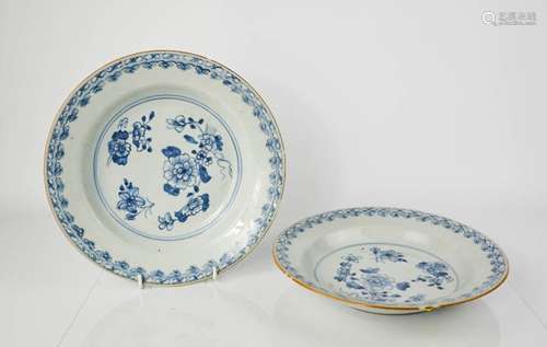 A pair of 19th century blue and white dishes, depicting flowers to the centre, 22cm diameter.