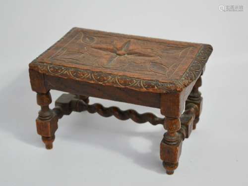 A small 19th century oak stool, with lunette carved edge and flowerhead to the centre, raised on