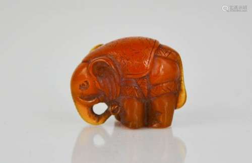 An amber netsuke bead in the form of an elephant, carved with detail, 3cm high.