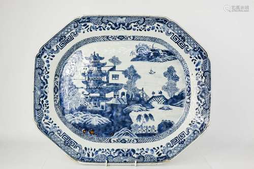 A large early 19th century Chinese blue and white platter, depicting buildings in landscape beside