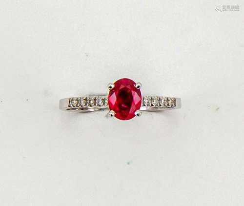 A 14ct white gold, ruby and diamond ring, the oval cut ruby approx 1ct, set iwth diamonds to the