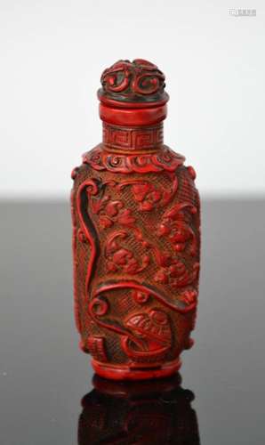 A Chinese hand carved coral coloured snuff bottle, of bees design