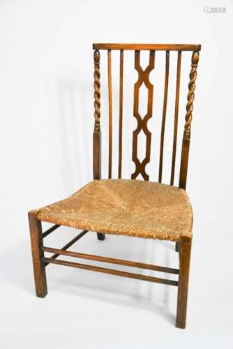 A 1930s prayer chair in oak, with rush seat and barleytwist supports.