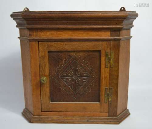 A small oak corner cupboard, with carved door.