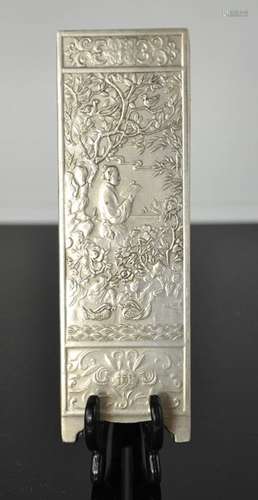 A Tibetan Miao silver scroll weight depicting scholar reading in garden, signed and stamped 180gm