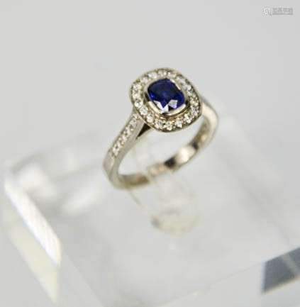 An 18ct white gold, sapphire and diamond ring, the cushion cut sapphire approx 0.90ct, surrounded by