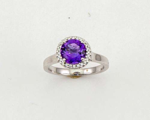 An 18ct gold, amethyst and diamond ring, the brilliant cut amethyst 1.52ct, the bordering diamonds