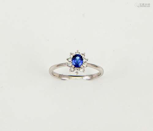 An 18ct white gold, sapphire and diamond ring, the oval cut 0.50ct sapphire bordered by 0.25ct