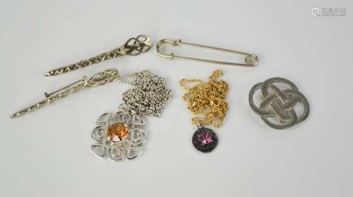 A group of vintage Scottish pendants, brooches, and a kilt pin, one pendant stamped CJ Scotland,