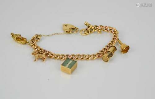 A 9ct gold charm bracelet, with six charms including ram, lantern, bell, violin, shoe and 1 pound
